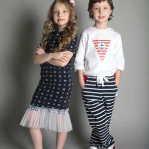 Two children posing in stylish nautical-themed outfits.